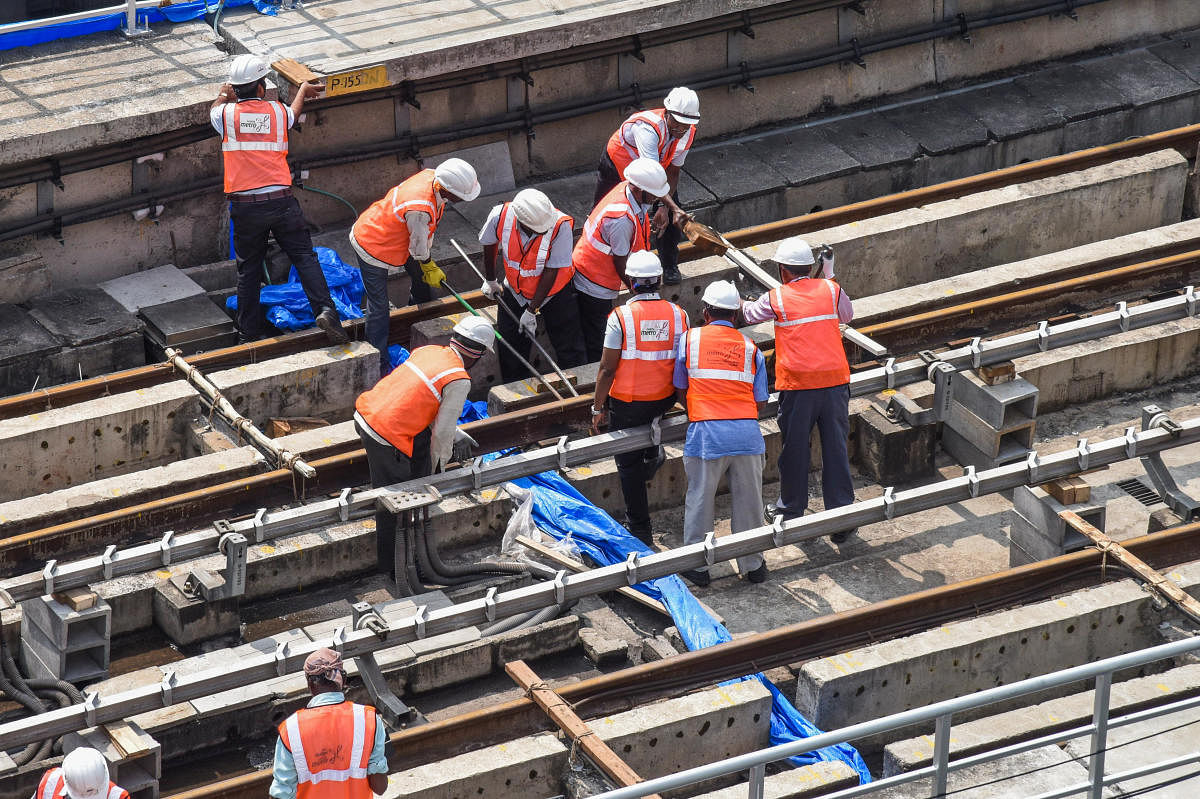 BMRCL employees at work near the Trinity Circle metro station, MG Road, Bengaluru. Credit: DH FILE PHOTO