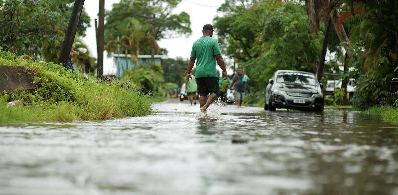 Residents wade through the flooded streets in Fiji's capital city of Suva. Credit: AFP Photo