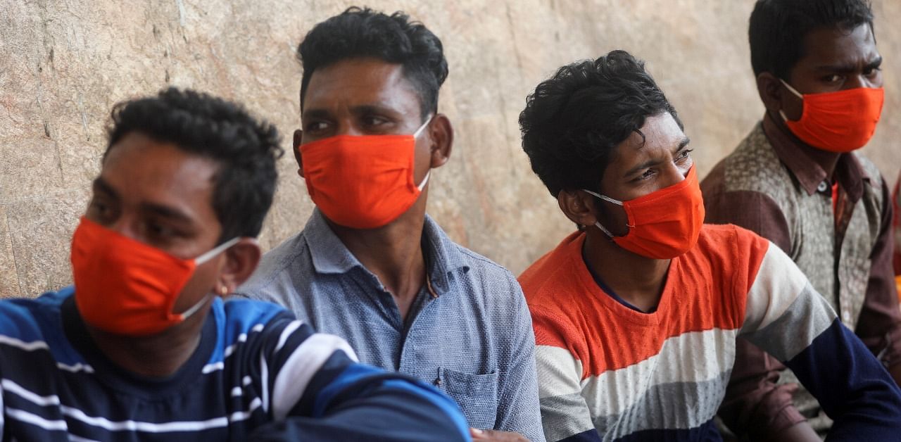 Men wearing protective masks wait to get tested during a rapid antigen testing campaign for the coronavirus disease, on the outskirts of Mumbai. Credit: Reuters Photo