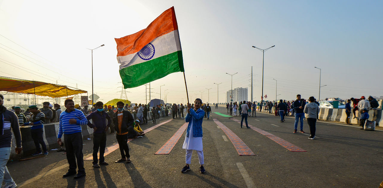 A youngster holds the tricolor at Ghazipur border during their protest against Centre's agri-laws, in New Delhi, Tuesday, Dec. 15, 2020. Credit: PTI Photo