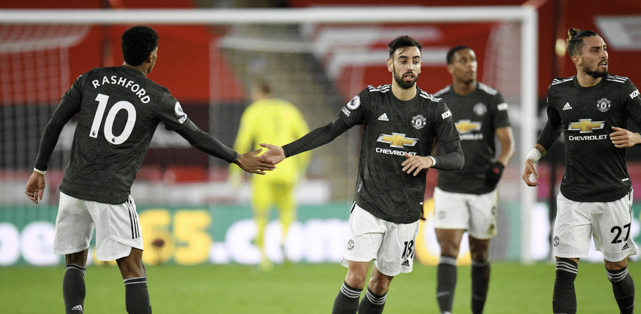 Manchester United's Marcus Rashford celebrates scoring their first goal with Bruno Fernandes. Credit: Reuters Photo 