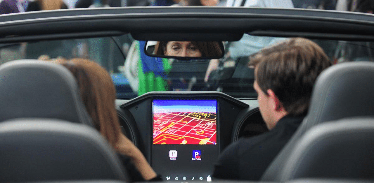 People seated in a Bentley discuss the QNX Technology options on the large display screen. Credit: AFP File Photo