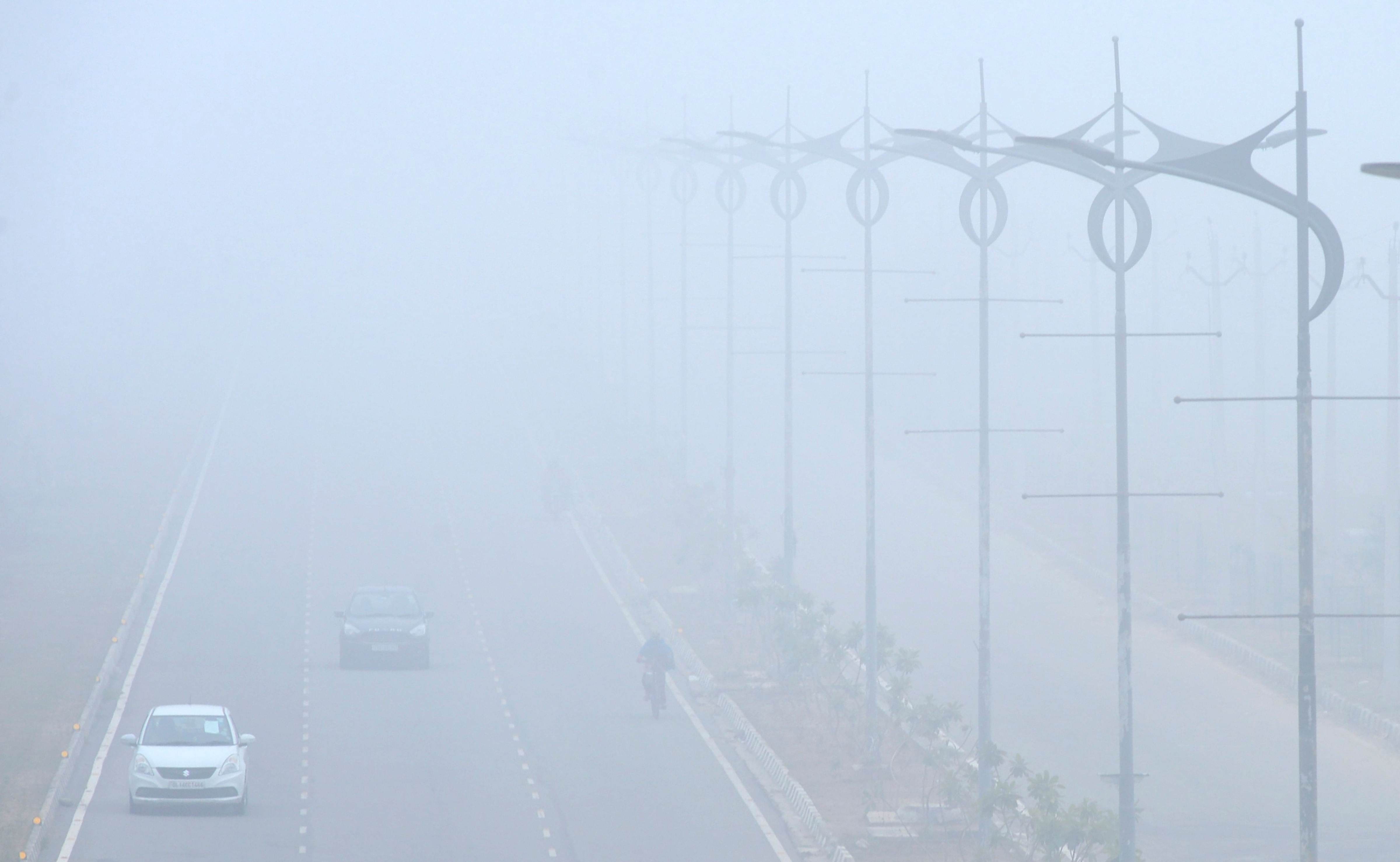Vehicles move slowly on a street, amid dense fog, during a cold morning, in Chandigarh, Thursday, Dec. 17, 2020. Credit: PTI Photo