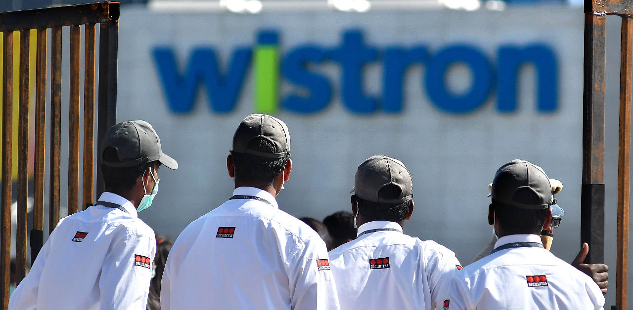 Security personnel stand guard outside Wistron Infocomm Manufacturing India Pvt Ltd at Narasapura area in Bengaluru. Credit: DH Photo/Pushkar V