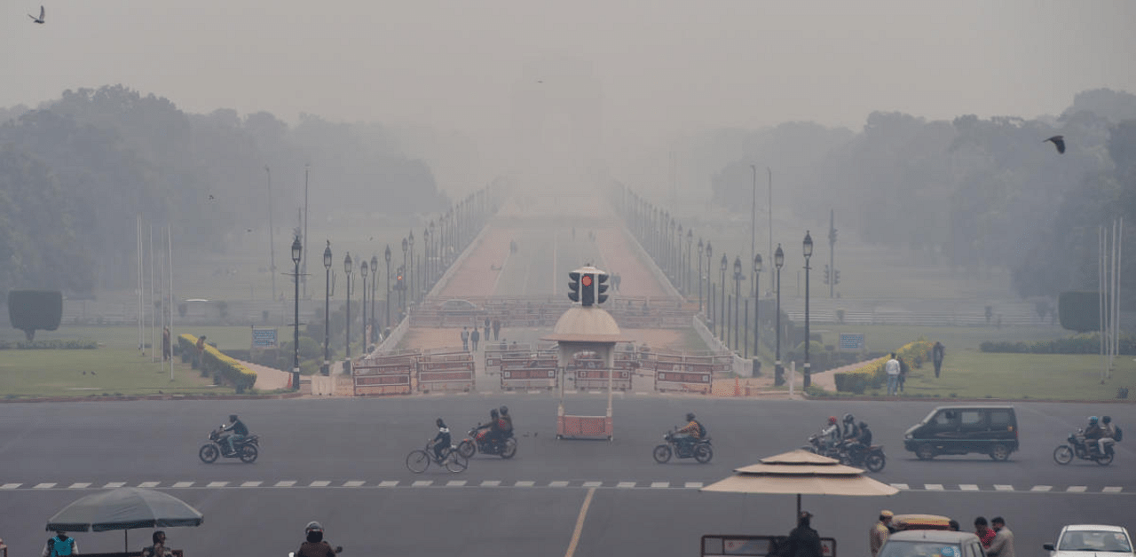 Vehicles ply at Vijay Chowk amid low visibility due to smog, in New Delhi, Wednesday. Credit: PTI Photo