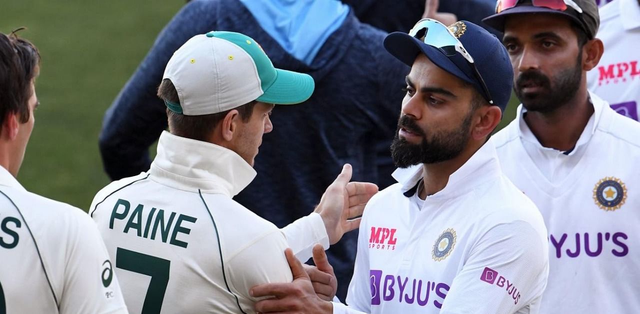 Virat Kohli congratulates Australia's captain Tim Paine (2/L) on the third day of the first cricket Test match between Australia and India played in Adelaide. Credit: AFP Photo