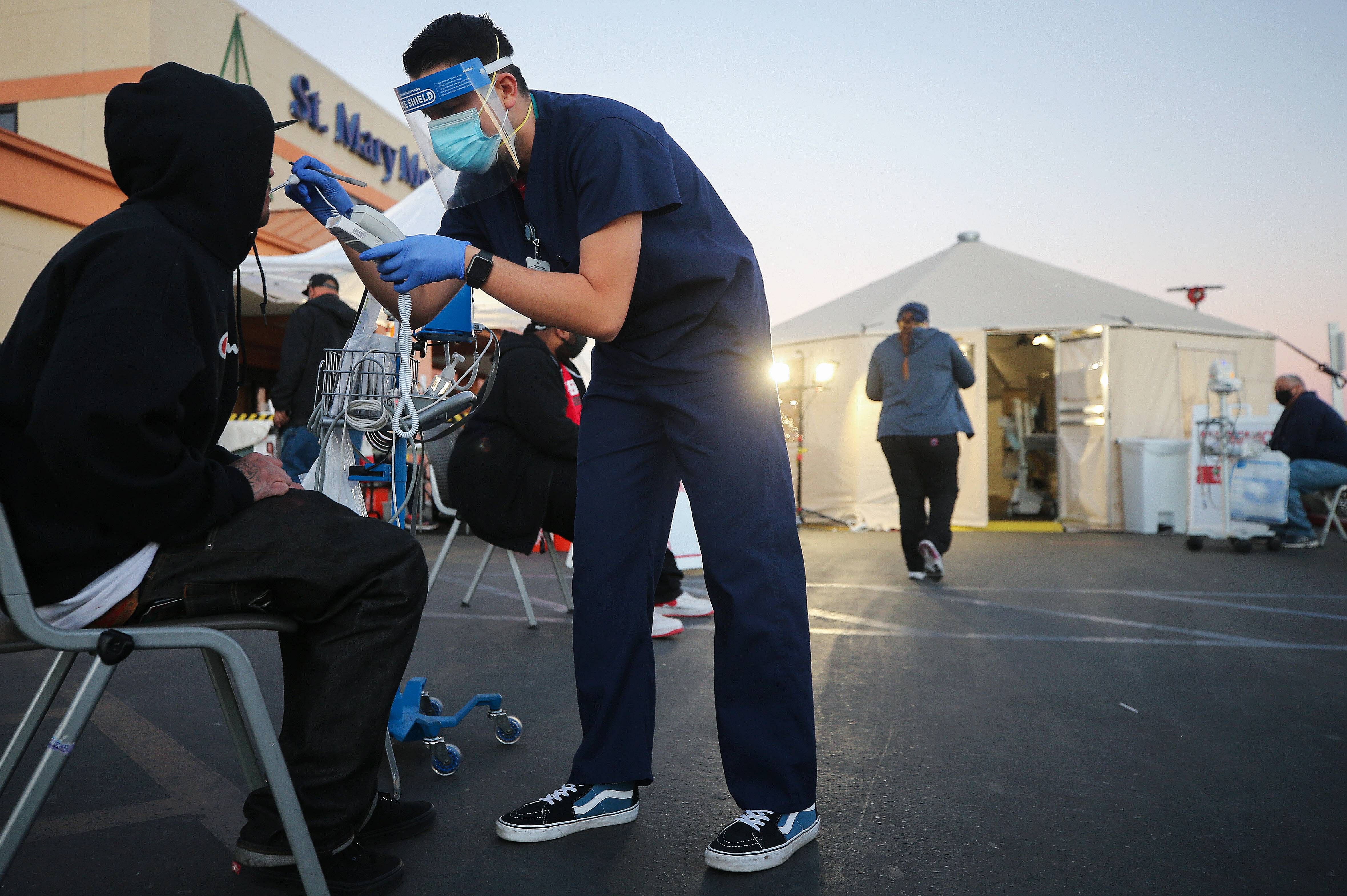 A California National Guard medic checks vital signs of an incoming patient in front of triage tents set up outside St Mary Medical Center amid a surge in Covid-19. Credit: AFP Photo