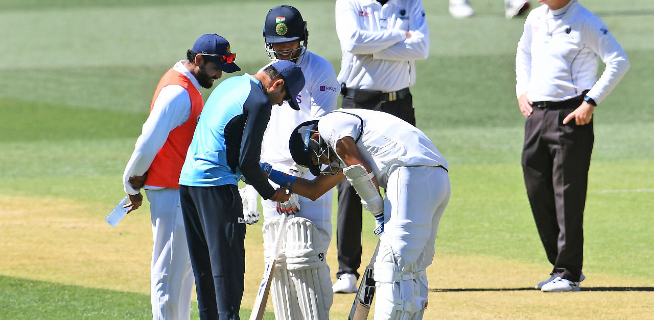 India's Mohammed Shami (C) receives treatment on his arm before retiring hurt on the third day of the first cricket Test match between Australia and India in Adelaide. Credit: AFP Photo