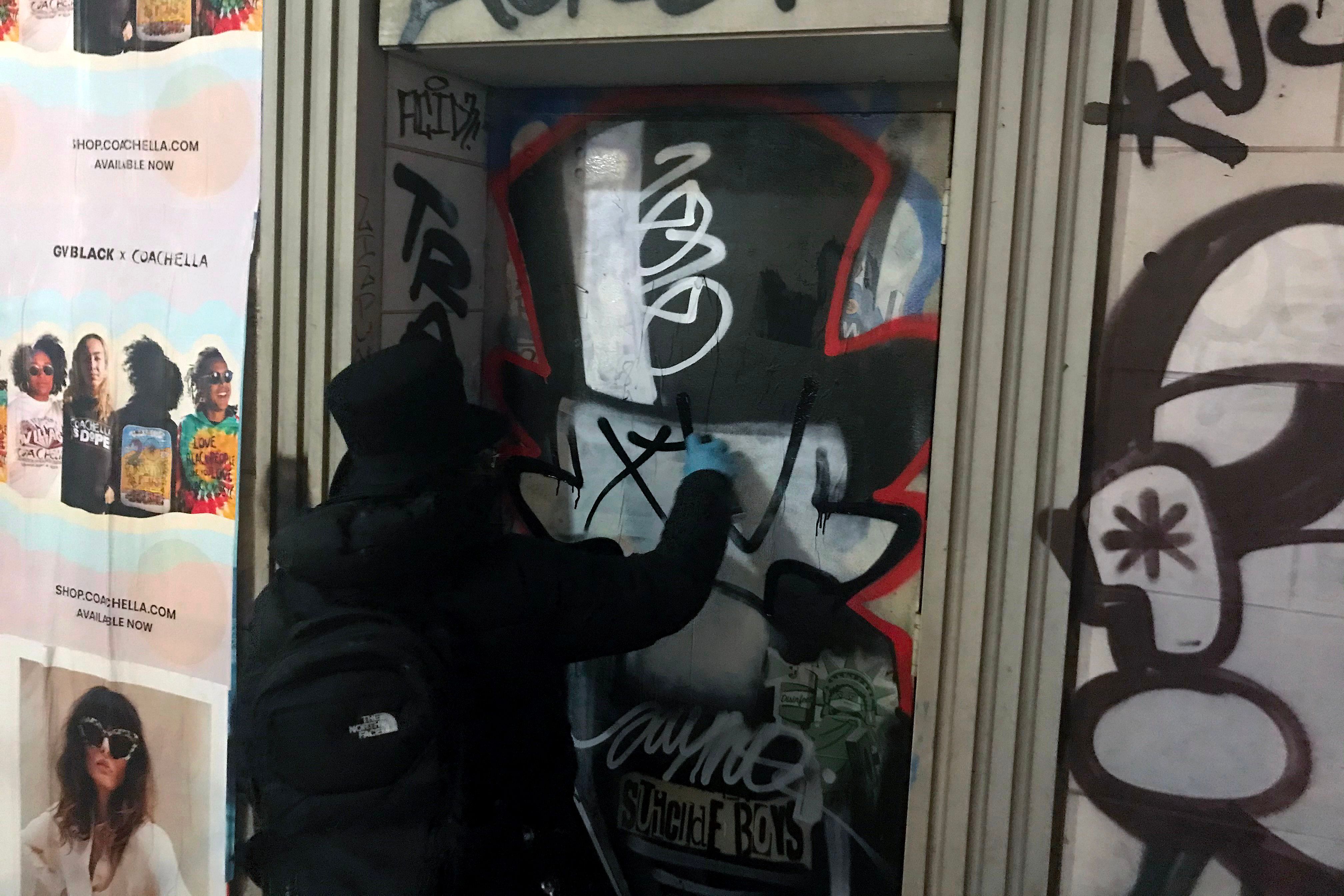 Graffiti artist "Saynosleep" paints a door in New York City. Credit: AFP Photo