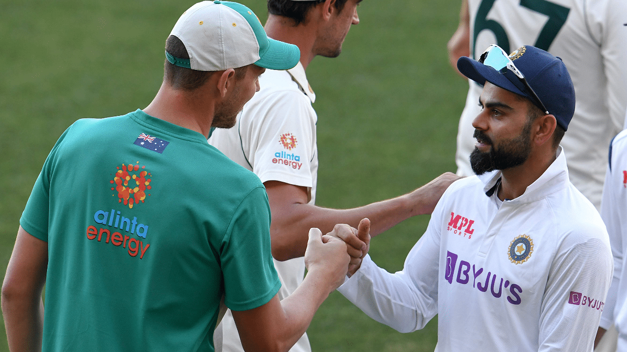 India's Virat Kohli (R) congratulates Australia's Josh Hazlewood on the third day of the first cricket Test match between Australia and India. Credit: AFP Photo