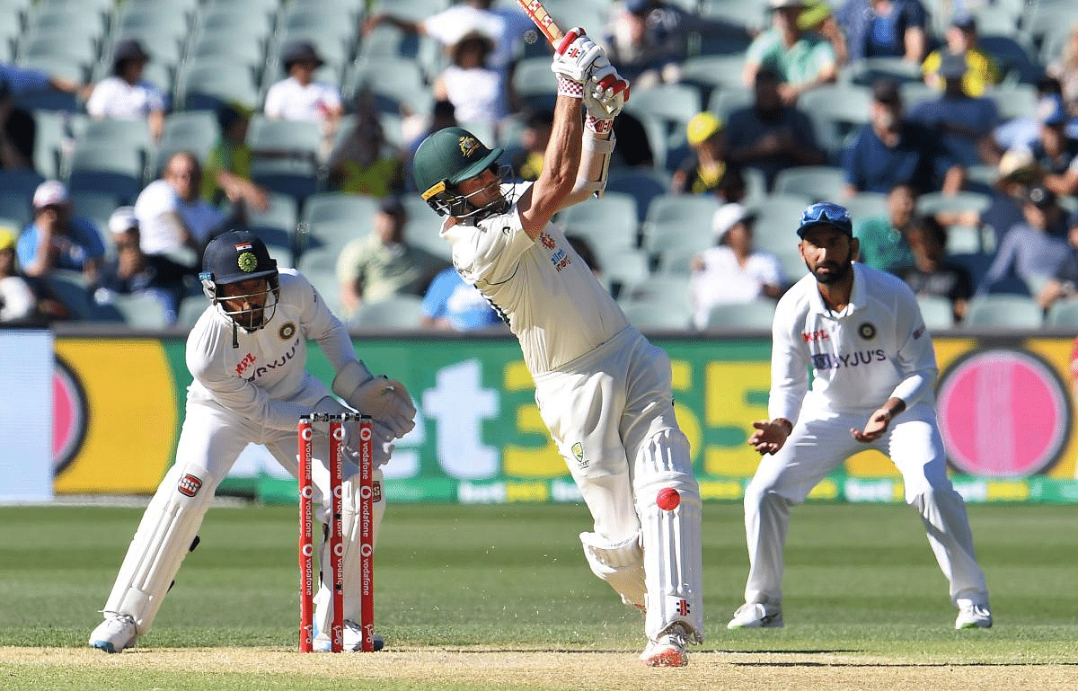 Australia's Joe Burns (C) hits out against the Indian bowling as Wriddhiman Saha (L) and Cheteshwar Pujara (R) react on the third day of the first cricket Test match between Australia and India played in Adelaide. Credit: AFP Photo