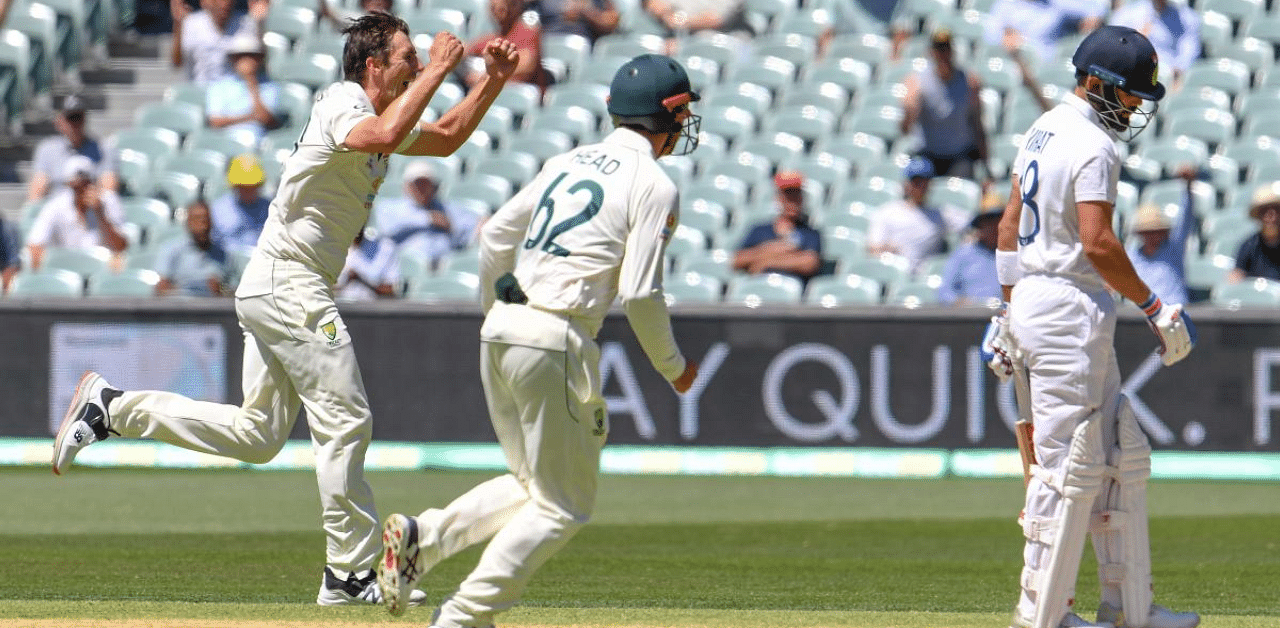 Australia's Pat Cummins (L) celebrtaes dismissing India's Virat Kohli (R) on the third day of the first Test match between Australia and India played in Adelaide. Credit: AFP