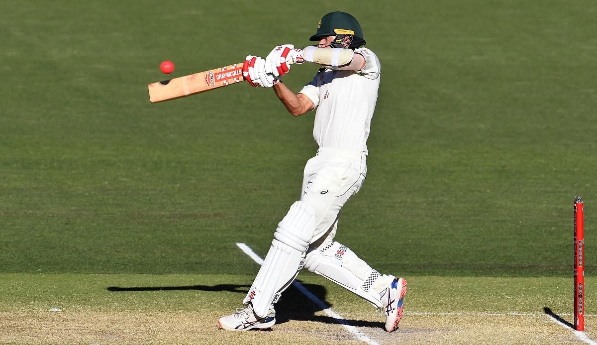 Australia's Joe Burns hits a six to bring up his 50 and victory for Australia on the third day of the first cricket Test match between Australia and India played in Adelaide. Credit: AFP Photo