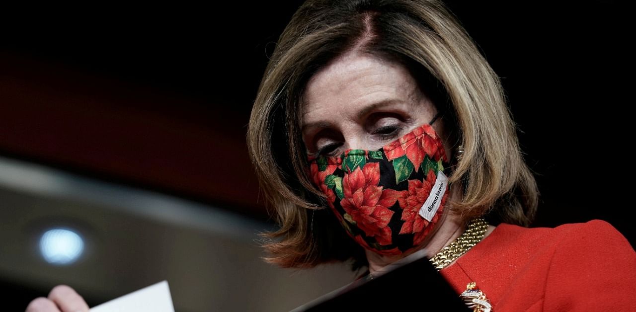 Speaker of the House Nancy Pelosi (D-CA) reads papers as Senate Minority Leader Charles Schumer (D-NY) (not pictured) speaks to reporters on an agreement of a coronavirus aid package. Credit: Reuters Photo