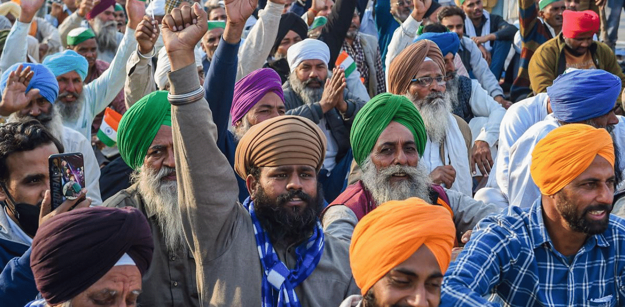 Farmers shout slogans while blocking a road at Ghazipur border during their ongoing agitation against the Centre's farm reform laws, in New Delhi. Credit: PTI Photo
