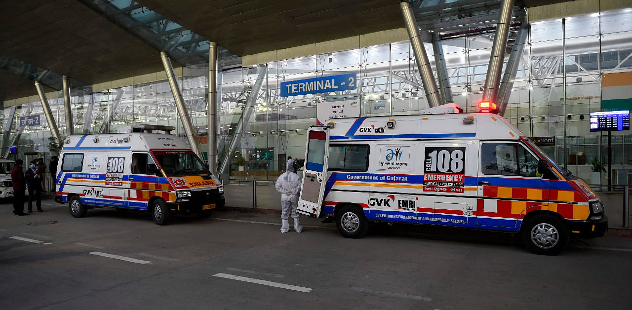 A health worker stands besides ambulances parked outside the Sardar Vallabhbhai Patel International Airport upon the arrival of passengers from United Kingdom. Credit: AFP Photo