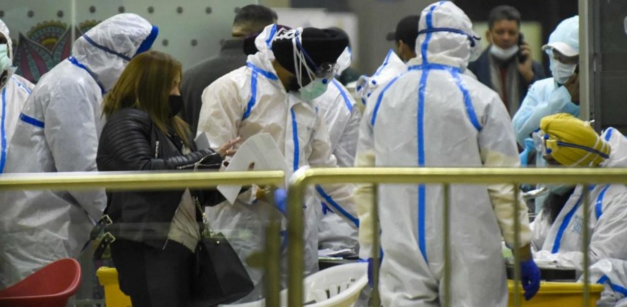 A passenger speaks with health workers before taking a Covid-19 coronavirus test upon her arrival from London at Sri Guru Ram Dass Jee International Airport on the outskirts of Amritsar on December 22, 2020. Credit: AFP Photo