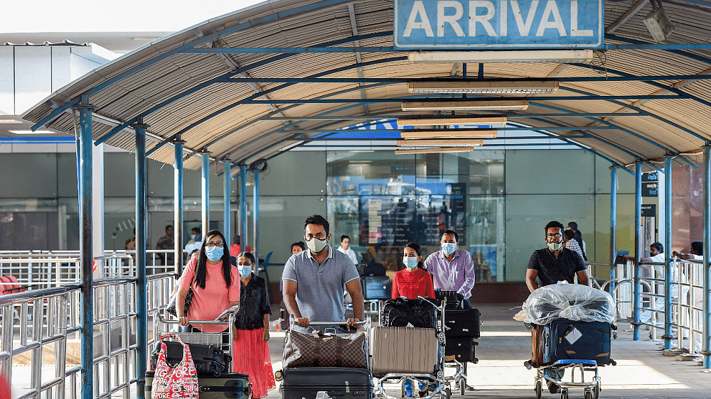 Passengers wear medical-masks as part of precautionary measures against coronavirus, at Chennai International Airport in Chennai. Credit: PTI Photo