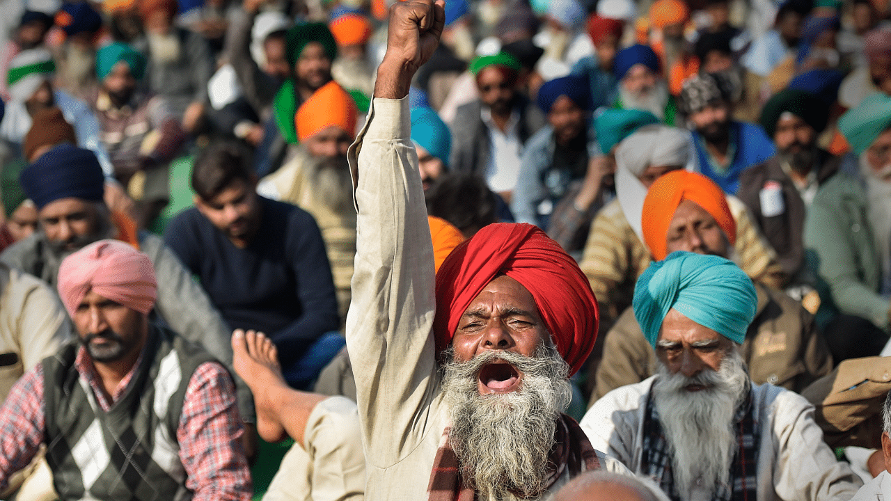 Farmers raise slogans during their protest against the farm laws at Singhu Border. Credit: PTI Photo