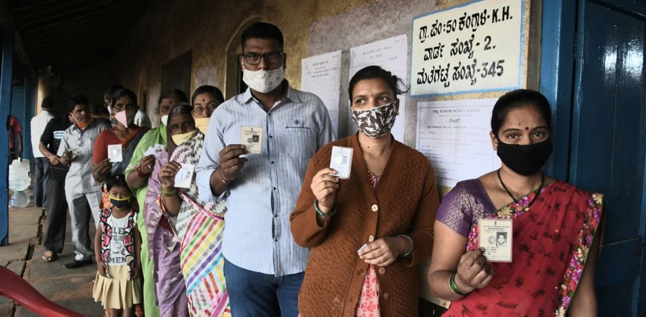 Voters show their identity cards during the polling for first phase of Gram Panchayat elections at a polling station at Kangrali K H village in Belagavi taluk on Tuesday. Credit: DH Photo/Eknath Agasimani