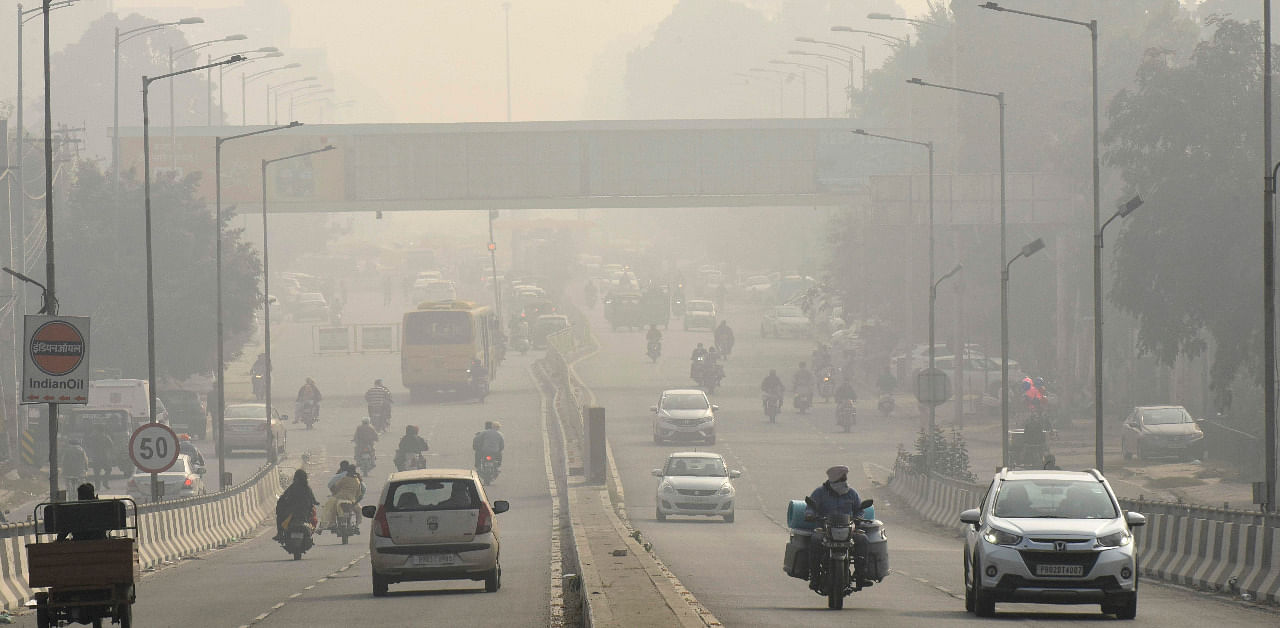 Commuters make their way along the road amid heavy smoggy condition in Amritsar. Credit: AFP Photo