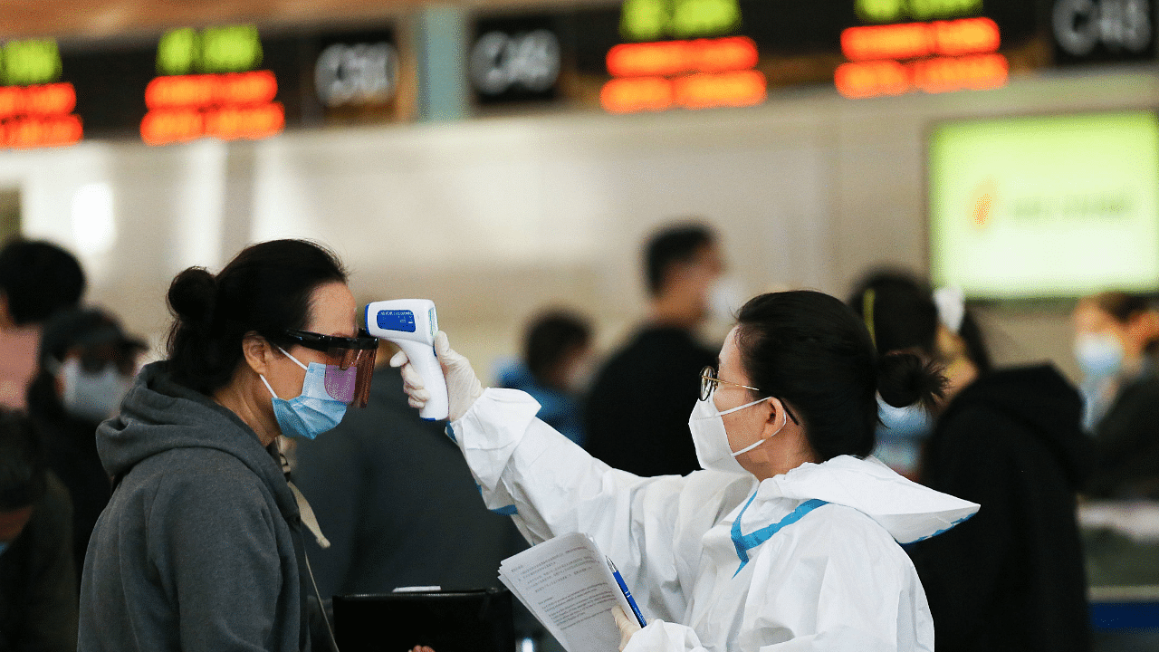A traveler receives a a temperature check before checking in for a China Airlines flight at the Tom Bradley International Terminal at Los Angeles International Airport (LAX) amid a Covid-19 surge. Credit: AFP Photo