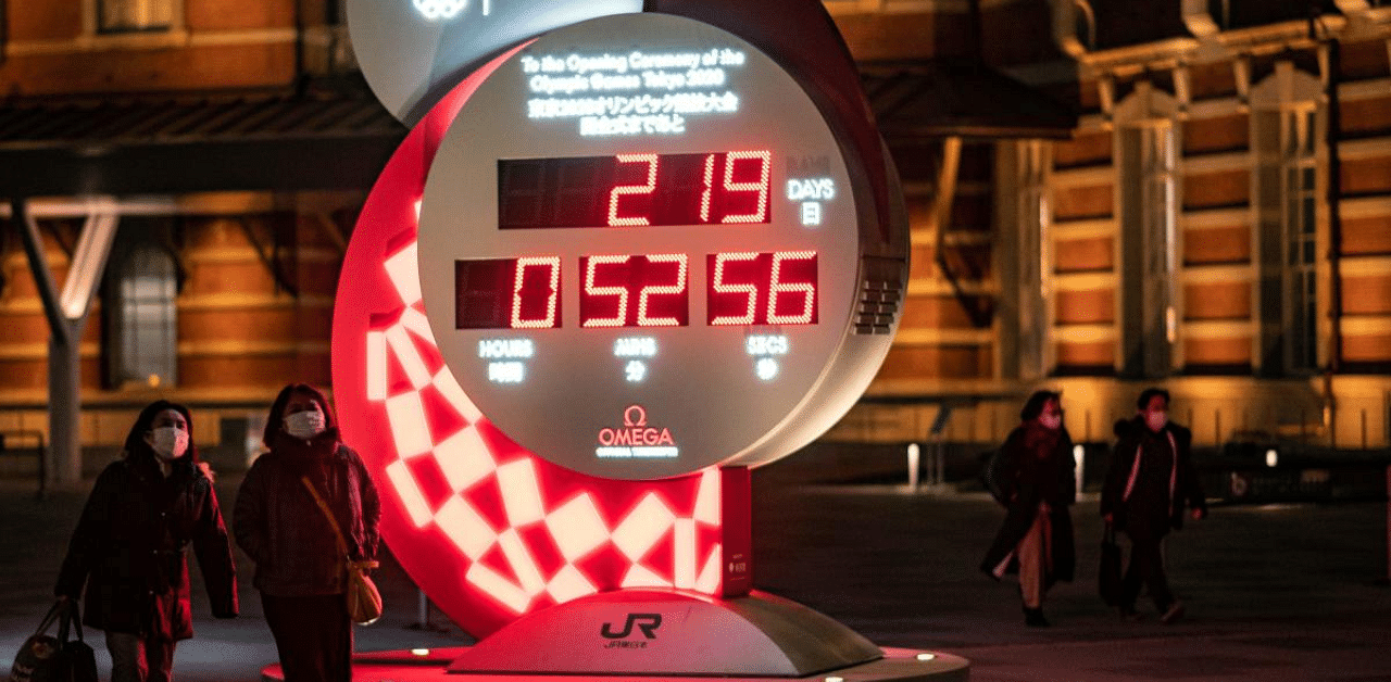 People walk past a countdown clock for the postponed Tokyo 2020 Olympic Games outside Tokyo railway station. Credit: AFP File Photo