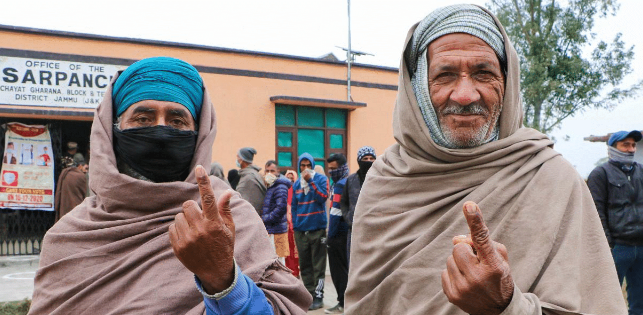 Voters show their fingers marked with indelible ink after casting their votes for the seventh phase of District Development Council (DDC) elections, at Suchetgarh village near India-Pakistan international border in Jammu district. Credit: PTI File Photo