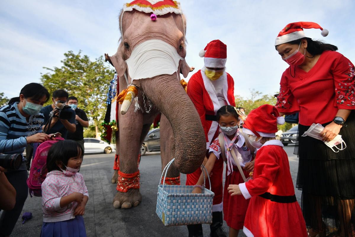 Students receive face masks from an elephant dressed as Santa Claus, in an effort to help prevent the spread of the coronavirus disease in Ayutthaya, Thailand. Credit: Reuters. 