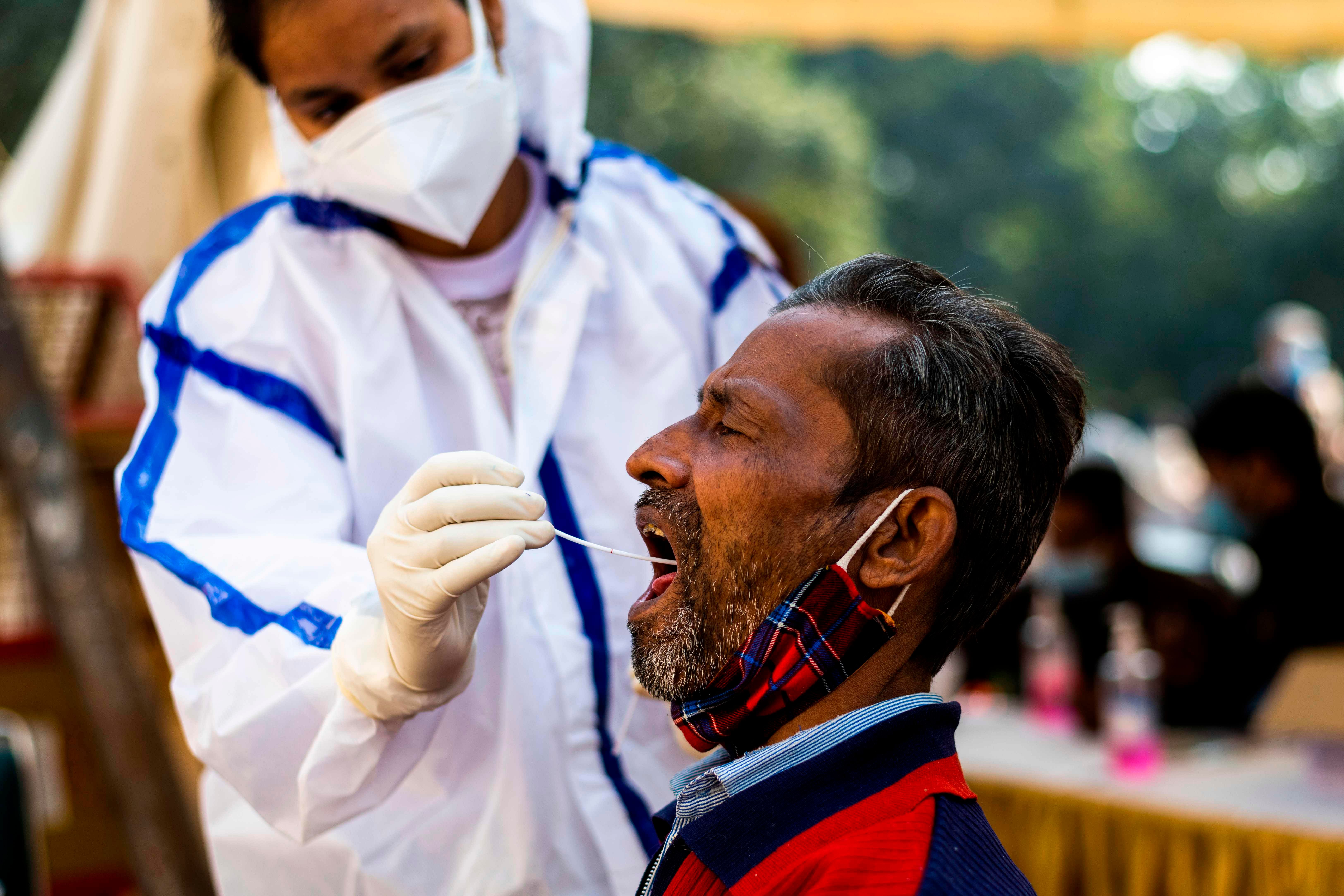 A health worker collects a swab sample from a shopper for Covid-19. Credit: AFP Photo