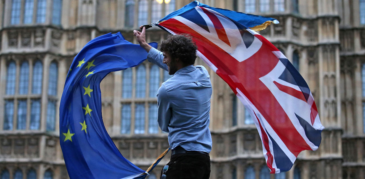 A man waves both a Union flag and a European flag together on College Green outside The Houses of Parliament at an anti-Brexit protest in central London. Credit: AFP File Photo