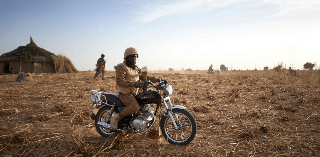 A soldier of the Burkina Faso Army sits on his motorcycle during a patrol in the Soum region in northern Burkina Faso. Credit: AFP File Photo