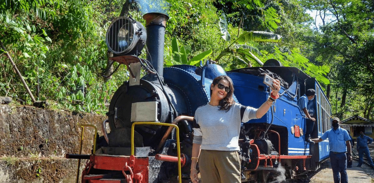 A woman takes a selfie during the trial run of Darjeeling Himalayan Railway (toy train) from Siliguri to Rongtong, in Darjeeling district. Credit: PTI File Photo