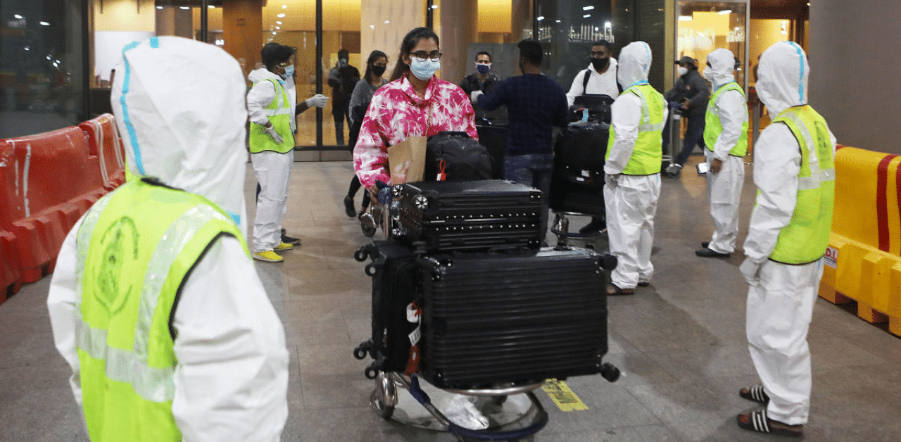 Passengers wearing protective face masks leave upon arrival at Chhatrapati Shivaji Maharaj International Airport after India cancelled all flights from the UK over fears of a new variant of the coronavirus disease. Credit: Reuters Photo