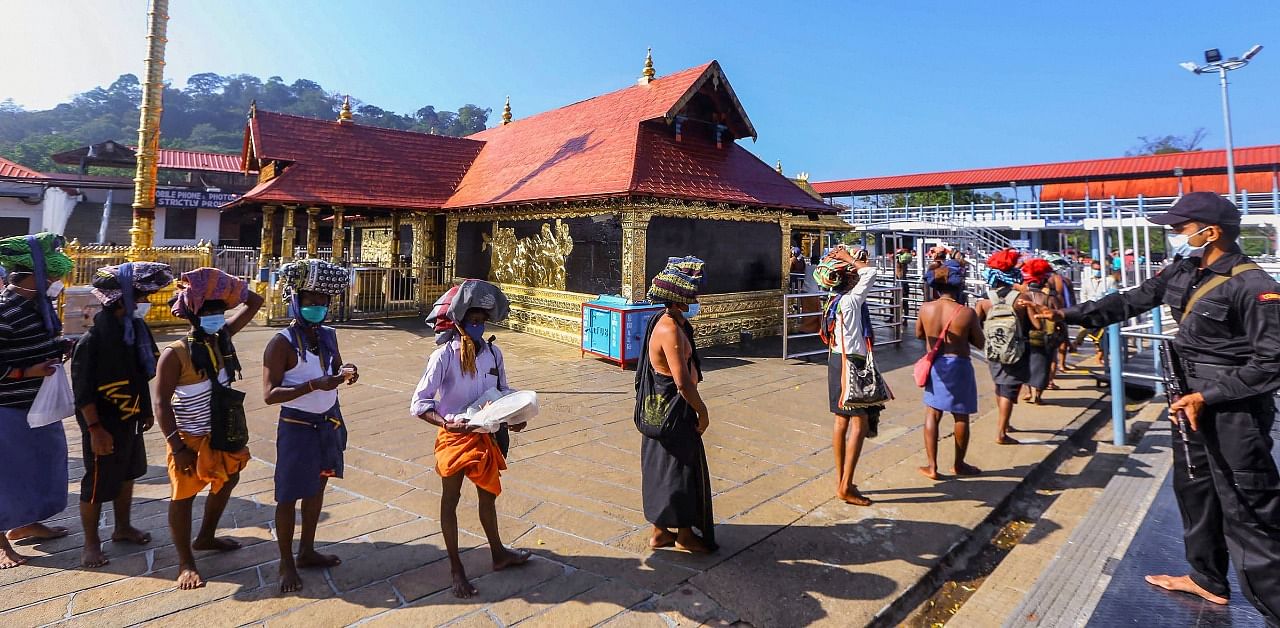 Devotees stand in a queue as they enter Sabarimala Temple, at Sabarimala in Pathanamthitta district on December 15. Credit: PTI Photo