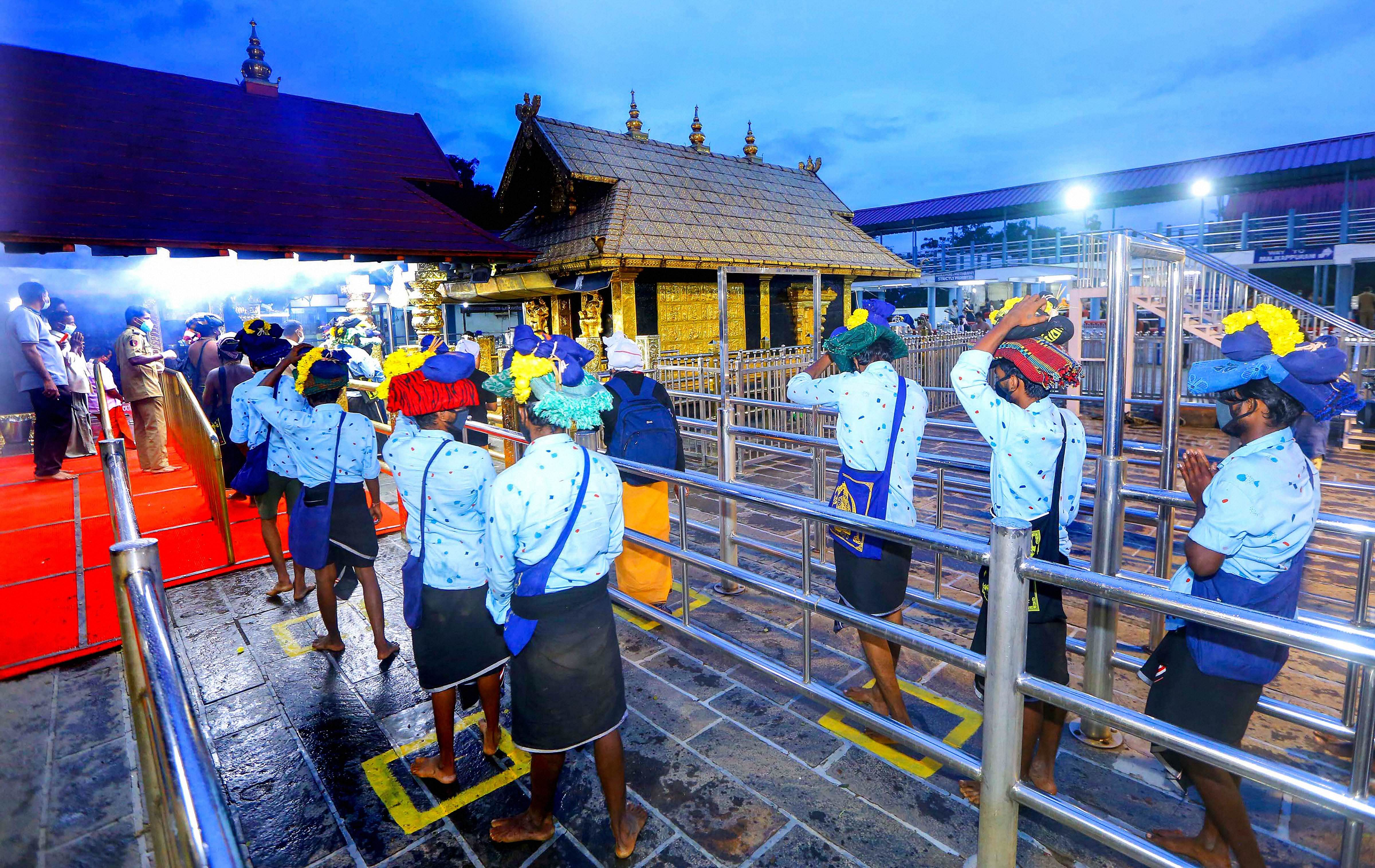 Devotees maintain social distance while standing in queues to offer prayers at Lord Ayyappa temple on the 1st day of Malayalam month of 'Vrischikom, at Sabarimala in Pathanamthitta, Monday, Nov. 16, 2020. Credit: PTI Photo