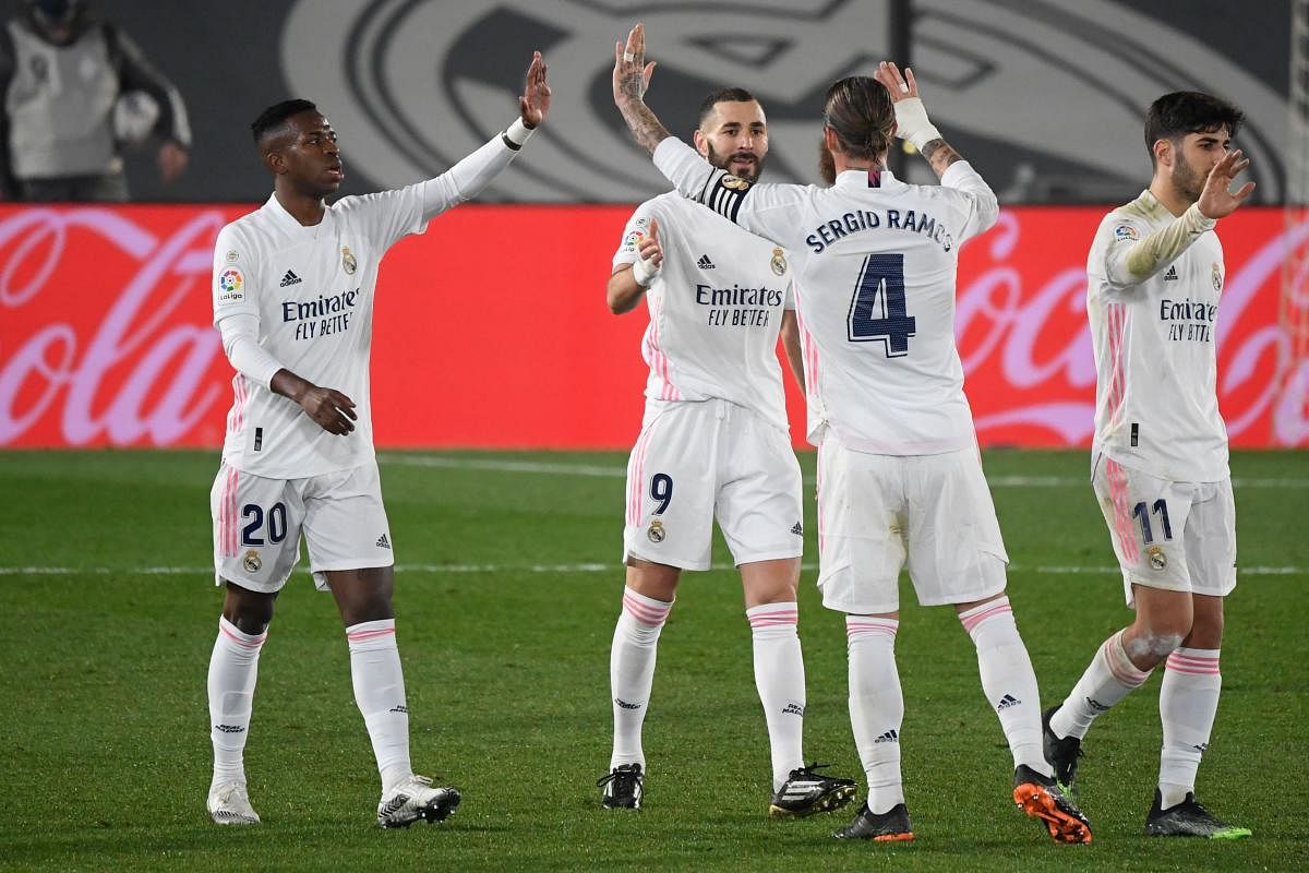 Real Madrid's French forward Karim Benzema (C) celebrates his goal during the Spanish league football match between Real Madrid CF and Granada FC at the Alfredo di Stefano stadium. Credit: AFP. 