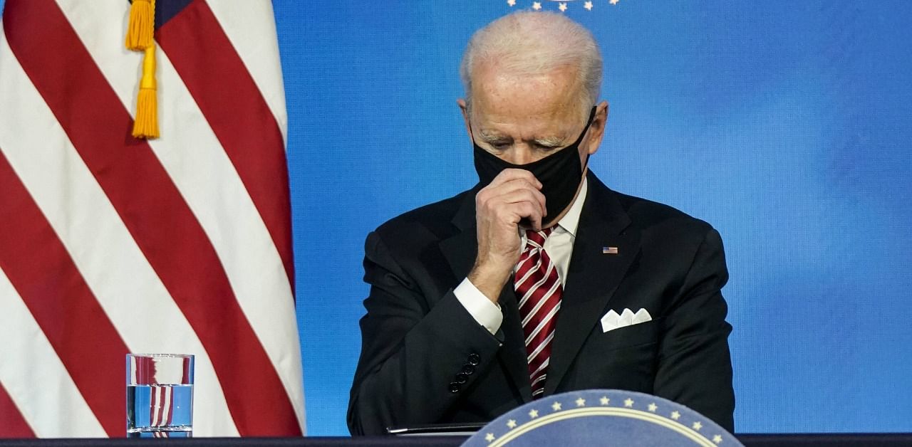 President-Elect Joe Biden adjusts his mask. Credit: AFP Photo