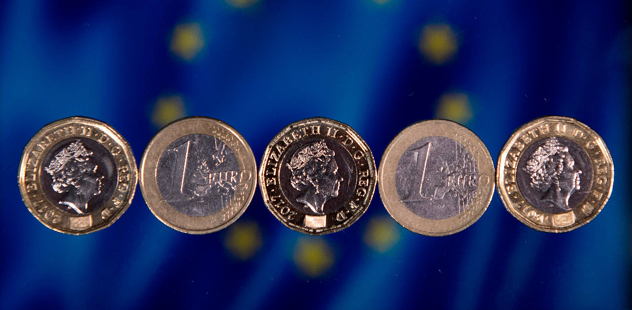 British one pound sterling coins and one Euro coins are arranged in front of the European Union flag. Credit: AFP File Photo