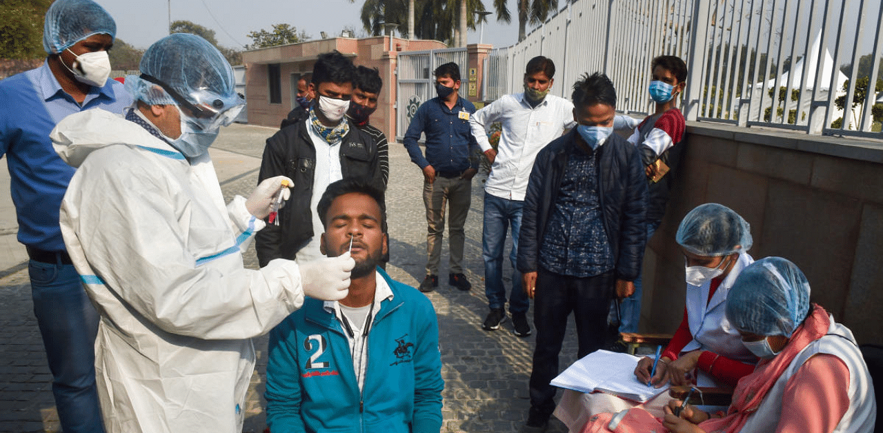 A health worker wearing PPE kit collects samples for the COVID-19 test at Sadaiv Atal Samadhi, as coronavirus cases surge across the National Capital, in New Delhi. Credit: PTI Photo