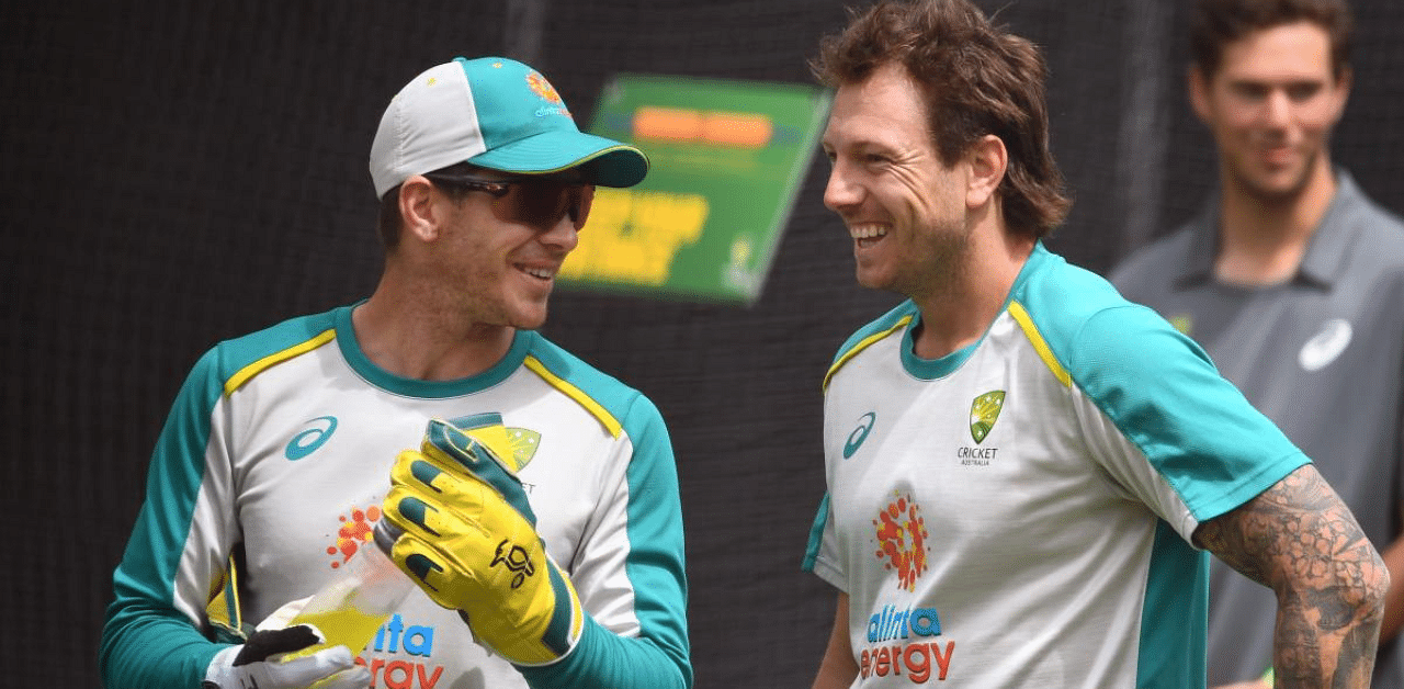 Australia's cricket captain Tim Paine (L) chats with James Pattinson (R) during a training session ahead of the second cricket Test match against India. Credit: AFP Photo