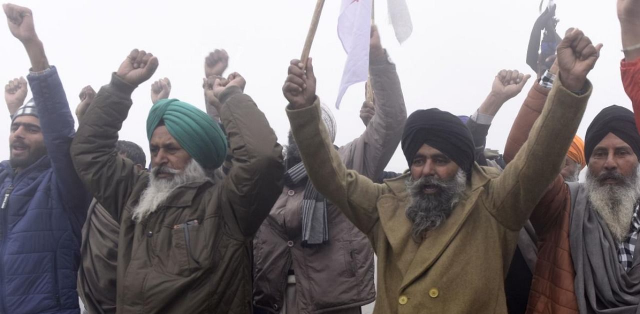Farmers shout slogans as they depart for Delhi to protest against the central government's recent agricultural reforms amid dense fog in Amritsar. Credit: AFP.