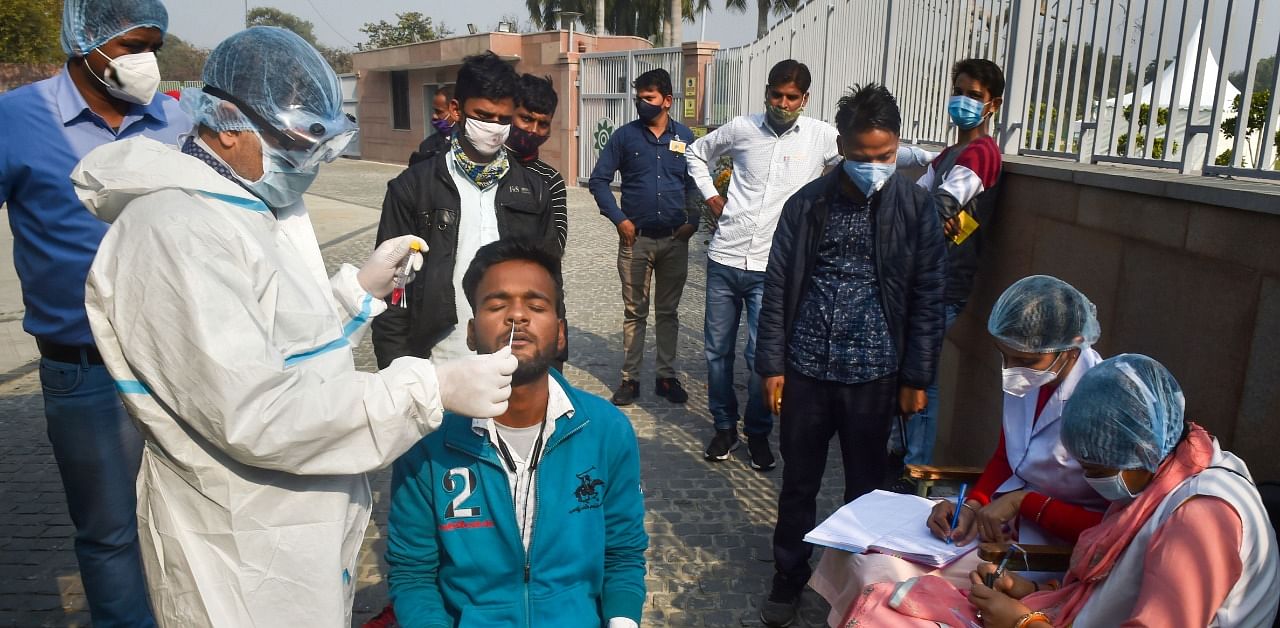A health worker wearing PPE kit collects samples for the Covid-19 test at Sadaiv Atal Samadhi, as coronavirus cases surge across the National Capital, in New Delhi. Credit: PTI Photo