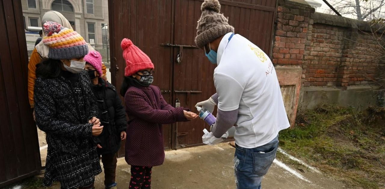 Christian devotees sanitize their hands as a preventive measure against Covid-19, before entering inside a church on Christmas Day in Srinagar. Credit: AFP.