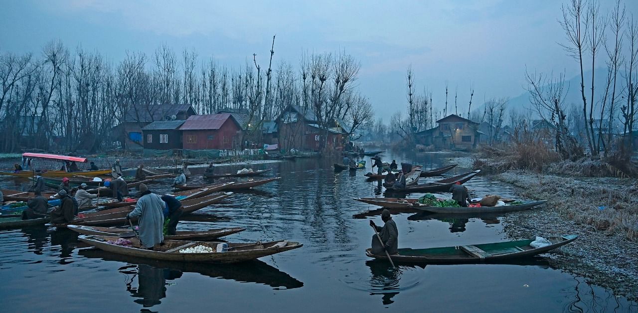 Vendors display their wares in an early morning floating vegetable-market at the interiors of Dal Lake, in Srinagar on December 21. Credit: AFP Photo