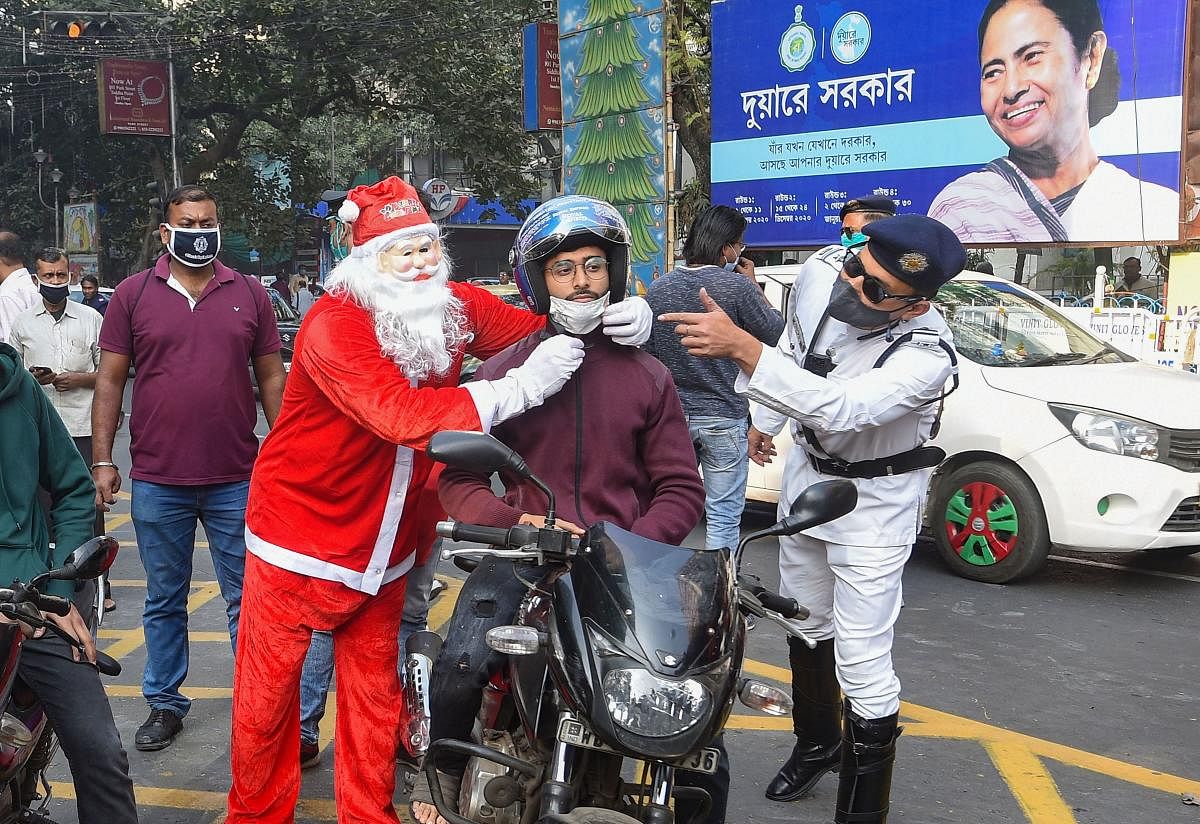 A police constable dressed as Santa Claus distributes helmets among commuters, amid coronavirus pandemic, in Kolkata. Credit: PTI. 