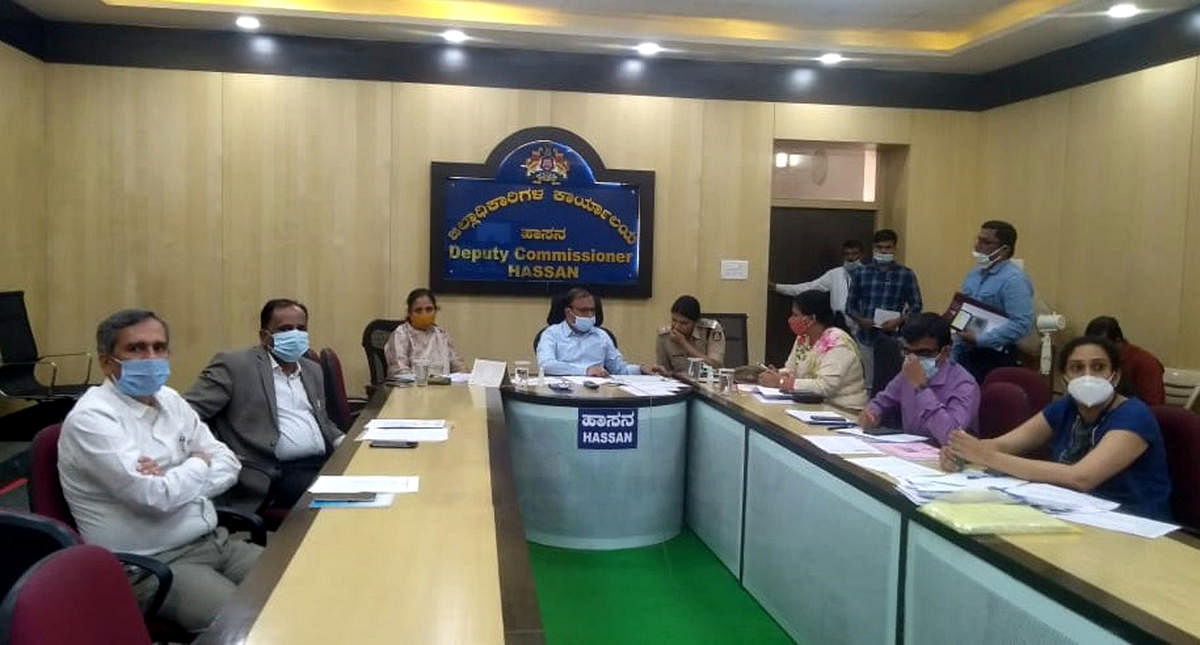 Deputy Commissioner R Girish and officials at a video conference with Chief Secretary T M Vijay Bhaskar in Hassan on Friday.