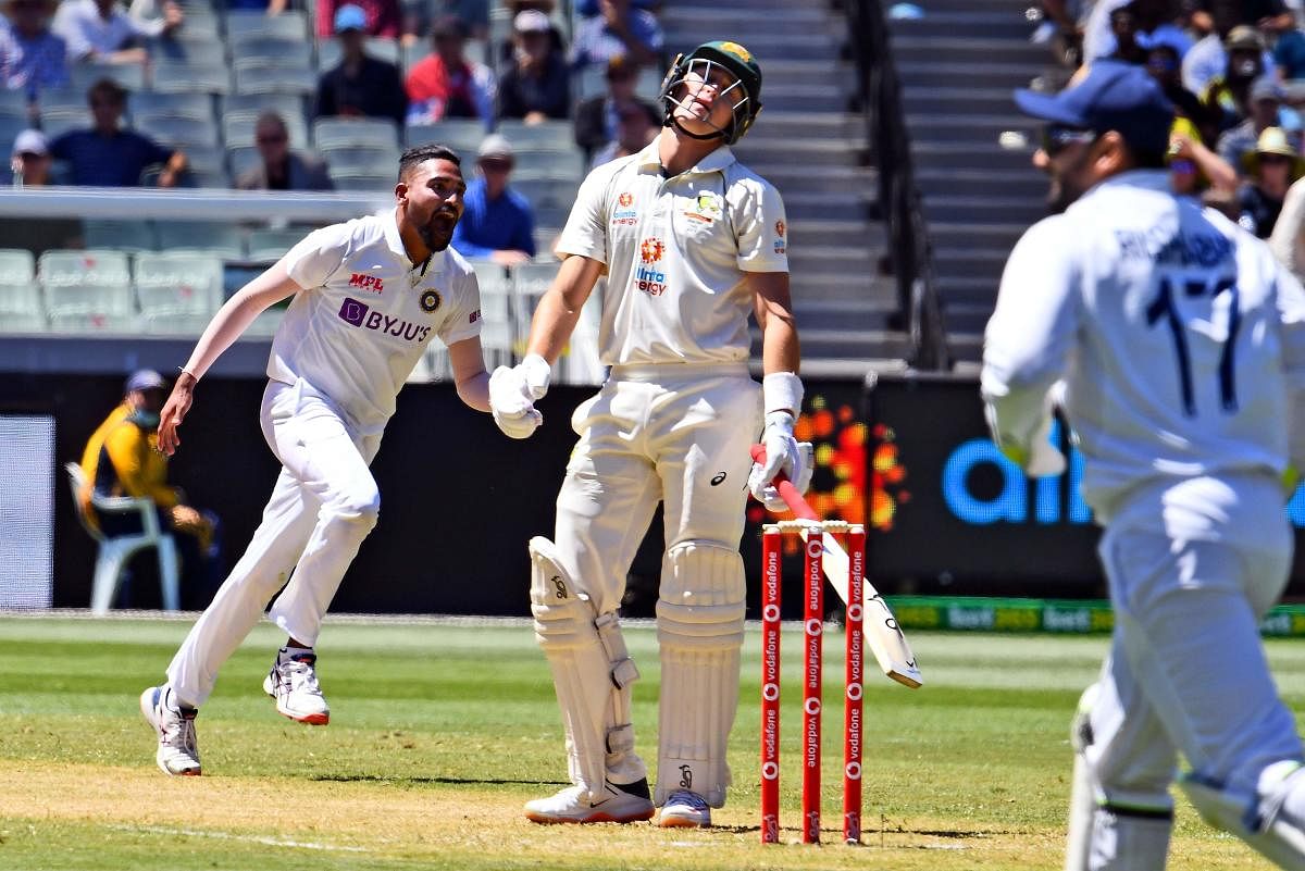 Mohammed Siraj (L) celebrates dismissing Australia's Marnus Labuschagne (C) on the first day of the second cricket Test match between Australia and India played at the MCG in Melbourne. Credit: AFP. 
