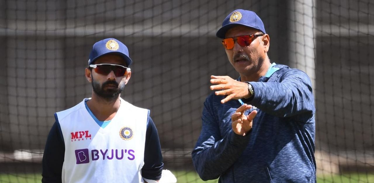 Ajinkya Rahane (L) chats with coach Ravi Shastri (R) during a training session ahead of the second cricket Test match against Australia. Credit: AFP Photo.