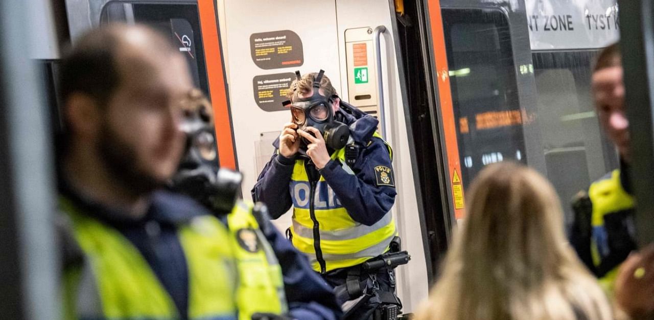 A Swedish policeman wears a protective mask at the border control point at Hyllie station. Credit: AFP.